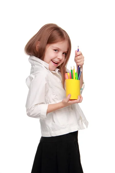 Молодая девушка с кучей карандашей, счастливо улыбающаяся — стоковое фото