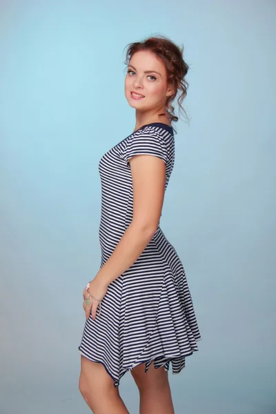 Beautiful woman in a striped dress — Stock Photo, Image