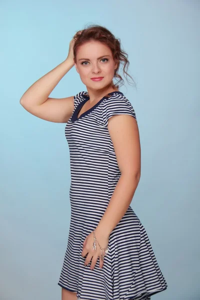 Beautiful woman in a striped dress — Stock Photo, Image