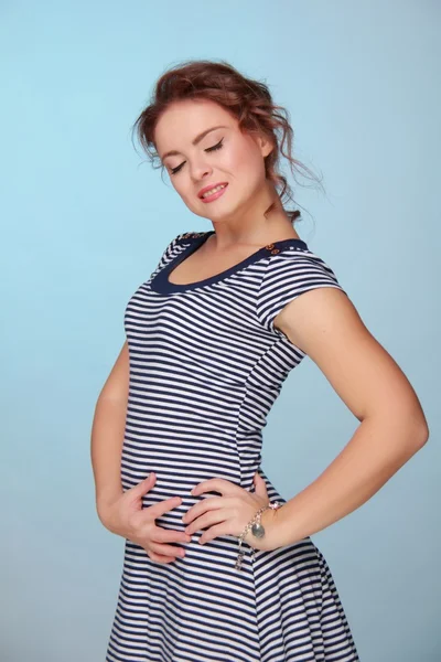 Beautiful woman in a striped dress — Stock Photo, Image