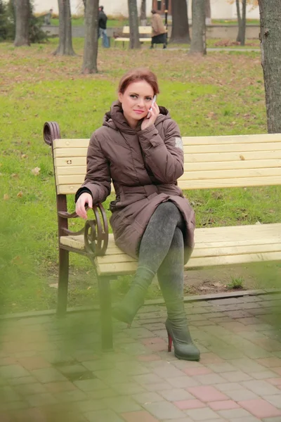 在电话上交谈的长凳上的女人 — 图库照片