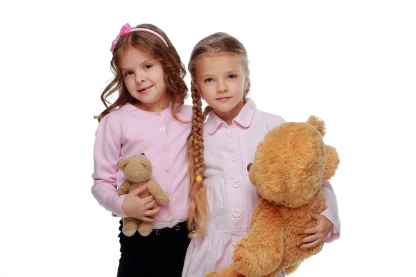 Kaksi tyttöä leikkii karhun kanssa — kuvapankkivalokuva