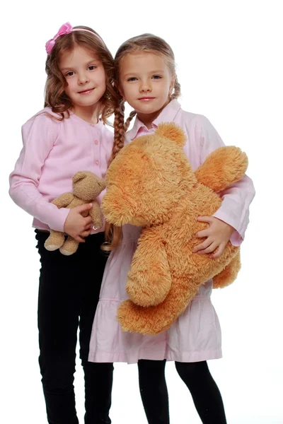 Две девушки играют с медведем — стоковое фото