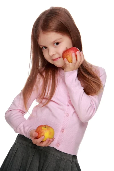 Schoolmeisje appels in haar armen houden — Stockfoto