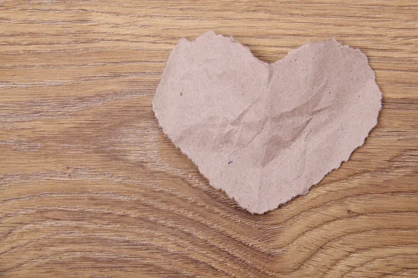 Heart symbol of the light of crumpled paper on a wooden background on Holiday — Stock Photo, Image