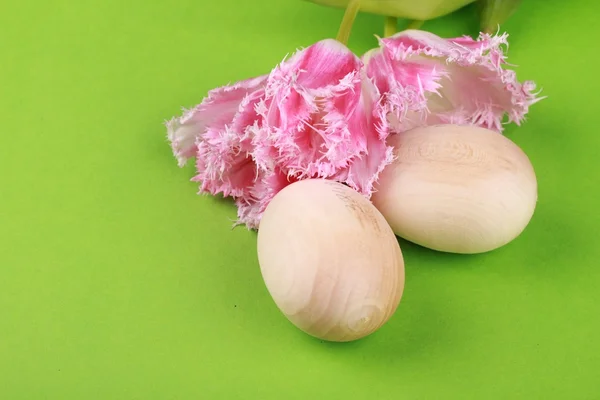 Imagem de estúdio de tulipas rosa e dois ovos de madeira — Fotografia de Stock