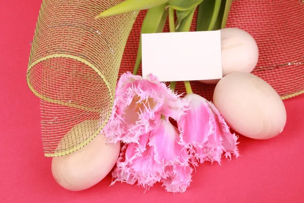 Pink tulips and eggs with a congratulatory card — Stock Photo, Image