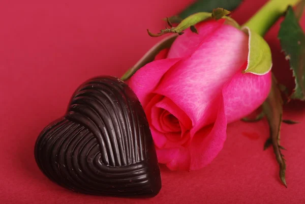 Hermosas rosas rosadas y corazones de chocolate — Foto de Stock