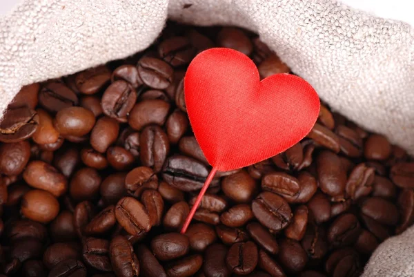 Chicchi di caffè marrone scuro con cuore rosso in vacanza — Foto Stock