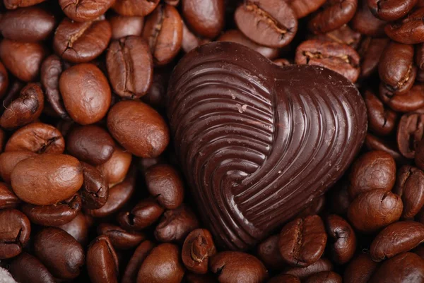 Темно-коричневые кофейные зерна и шоколадные конфеты — стоковое фото