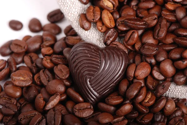 Темно-коричневые кофейные зерна и шоколадные конфеты — стоковое фото