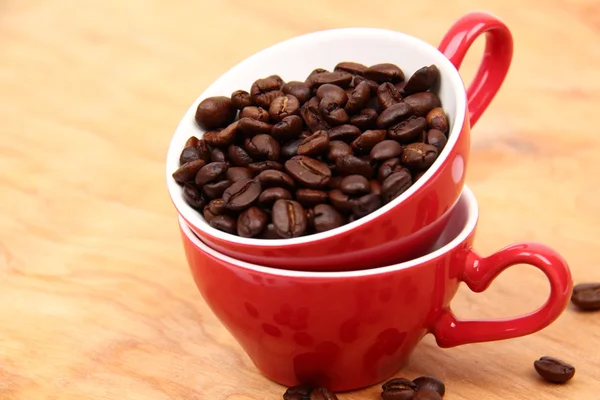 Dos tazas de café rojo con granos de café —  Fotos de Stock