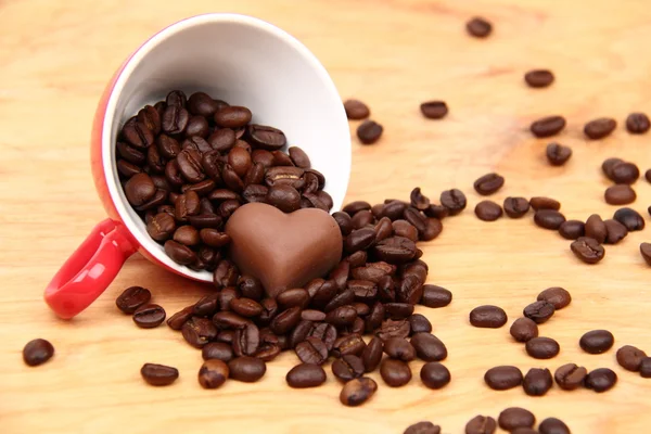 Tasse avec grains de café et bonbons au chocolat — Photo