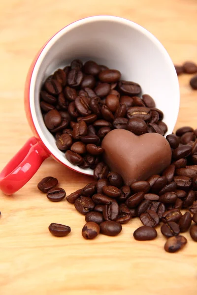 Tazza con chicchi di caffè e caramelle al cioccolato — Foto Stock