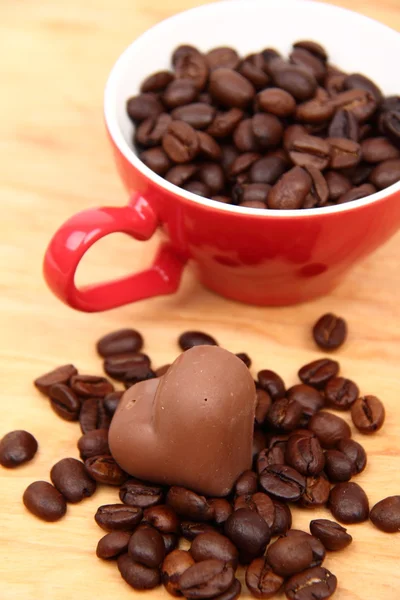 Tasse avec grains de café et bonbons au chocolat — Photo