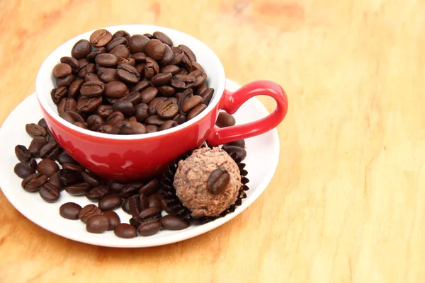 Cup with coffee beans and chocolate cake — Stock Photo, Image