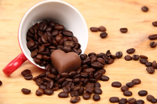 Tasse avec grains de café et bonbons au chocolat — Photo