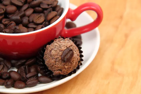 Tasse mit Kaffeebohnen und Schokoladenkuchen — Stockfoto