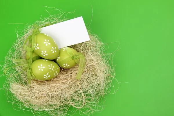 Uova di colore pasquale in nido con carta — Foto Stock