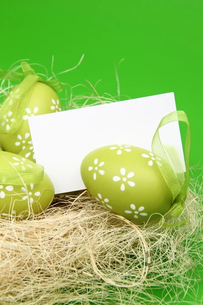 Ovos de cor de Páscoa em ninho com cartão — Fotografia de Stock