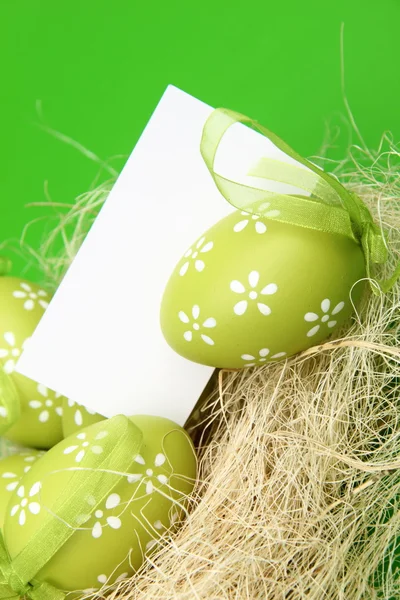 Ovos de cor de Páscoa em ninho com cartão — Fotografia de Stock