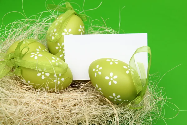 Easter color eggs in nest with card — Stock Photo, Image