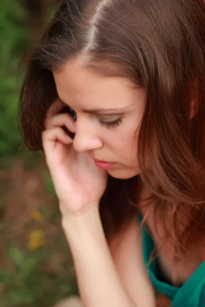 Ragazza in abito verde con un cellulare in mano — Foto Stock