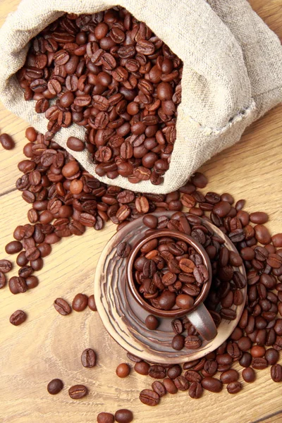 Chicchi di caffè marrone scuro con tazza di ceramica — Foto Stock