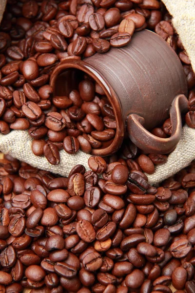 Deliciosos granos de café marrón en taza de café de cerámica — Foto de Stock