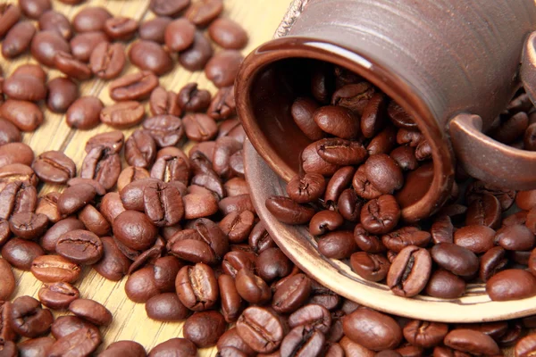 Deliziosi chicchi di caffè marrone in tazza di caffè in ceramica — Foto Stock