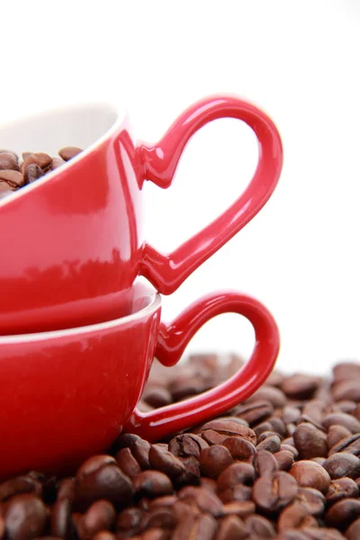 Grãos de café em xícara de café cerâmica com símbolo de coração — Fotografia de Stock