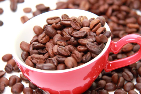 Granos de café en taza de café con símbolo del corazón —  Fotos de Stock