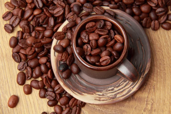 Köstliche Kaffeebohnen in keramischer Kaffeetasse — Stockfoto