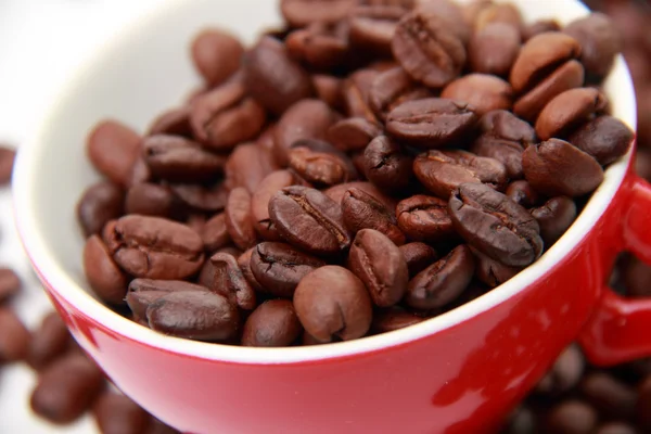 Vista superior em grãos de café em copo vermelho — Fotografia de Stock