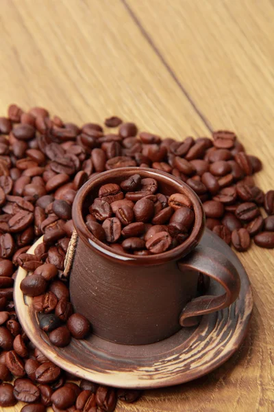 Delicious dark brown coffee beans in ceramic coffee cup — Stock Photo, Image