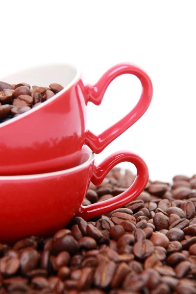 Grãos de café em xícara de café vermelho com símbolo de coração — Fotografia de Stock