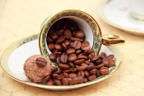 Xícara de café cheia de grãos de café na toalha de mesa — Fotografia de Stock