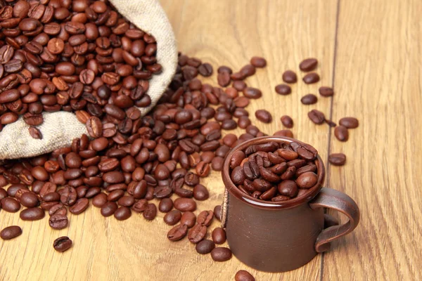 Dark brown coffee beans with ceramic coffee cup — Stock Photo, Image