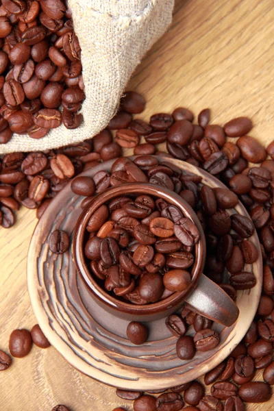 Chicchi di caffè marrone scuro con tazza di caffè in ceramica — Foto Stock