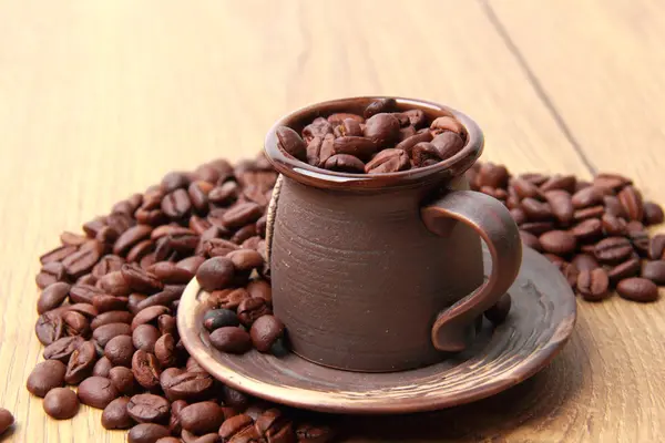 Köstliche dunkelbraune Kaffeebohnen in keramischer Kaffeetasse — Stockfoto