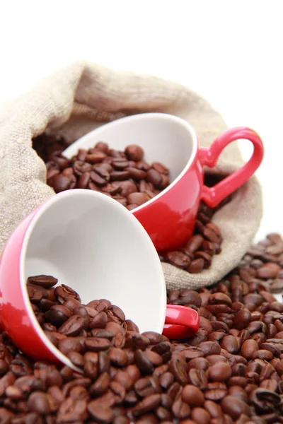 Grãos de café em copos vermelhos sobre saco de serapilheira — Fotografia de Stock
