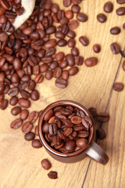 Chicchi di caffè marrone scuro con tazza di ceramica — Foto Stock