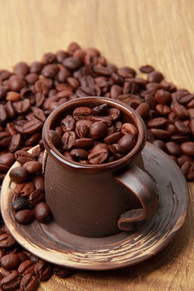 Delicious dark brown coffee beans in ceramic coffee cup — Stock Photo, Image