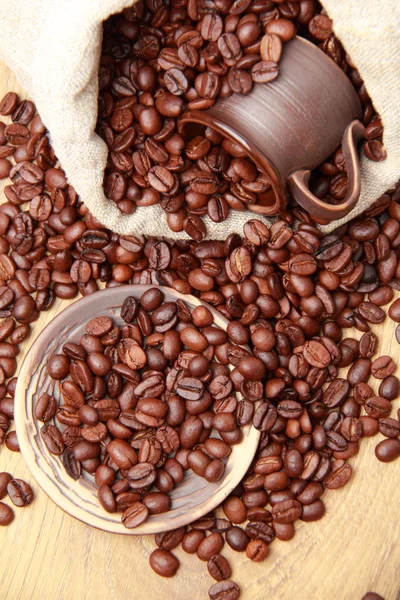 Chicchi di caffè marrone scuro con tazza di caffè e piattino — Foto Stock