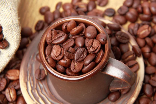 Biji kopi coklat gelap dengan cangkir kopi keramik — Stok Foto