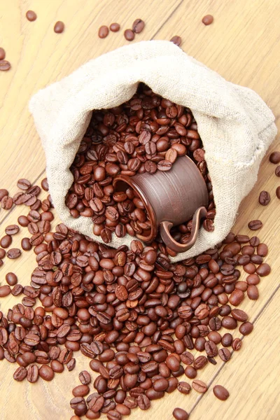 Dunkelbraune Kaffeebohnen mit keramischer Kaffeetasse — Stockfoto