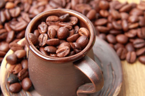 Deliziosi chicchi di caffè in piccola tazza di caffè in ceramica — Foto Stock