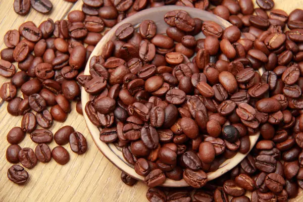 Granos de café sobre fondo texturizado de madera —  Fotos de Stock