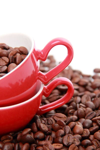 Granos de café en taza roja con símbolo del corazón —  Fotos de Stock