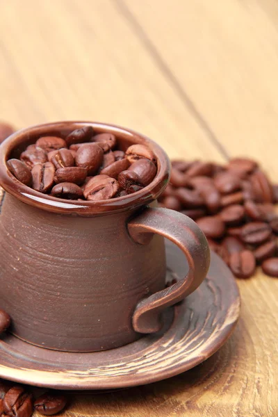 Delicious dark brown coffee beans in small ceramic coffee cup — Stock Photo, Image